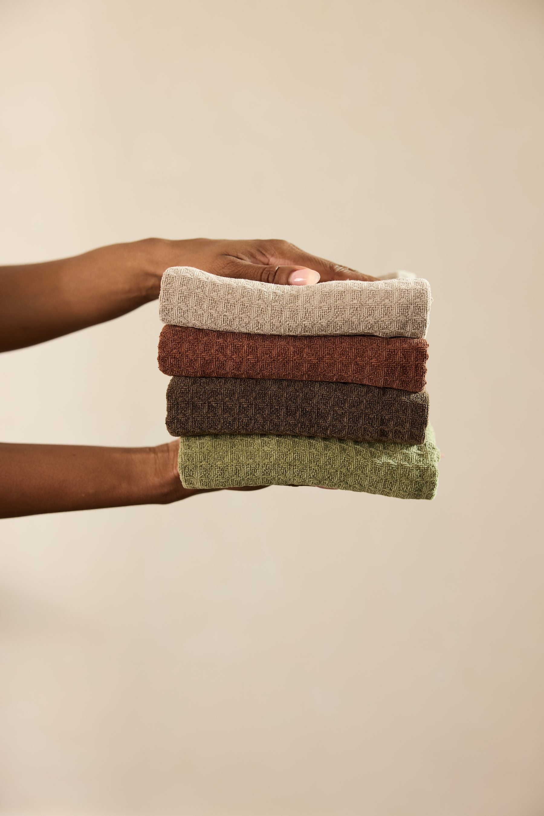 A stack of folded Geometry towels in a curated palette of grounded hues